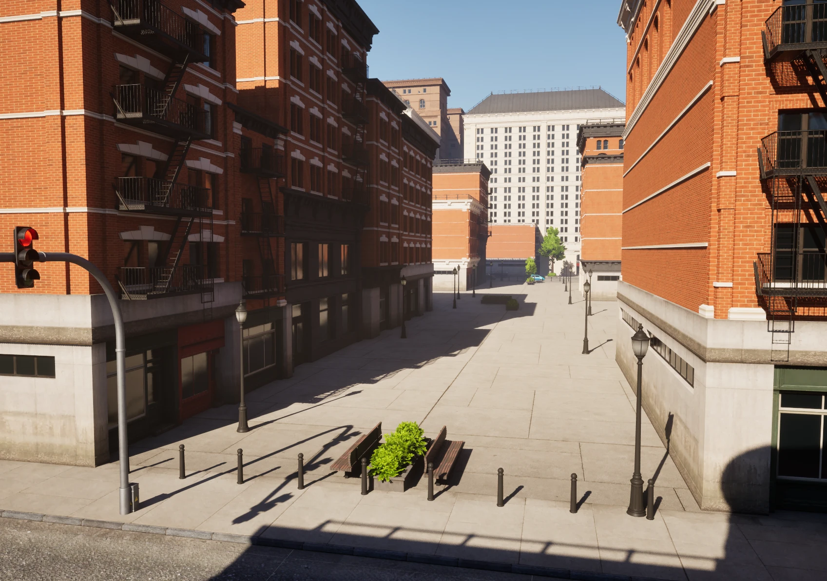 A pedestrianised street between two blocks: bollards lined across the mouth where it meets the road, benches, planters, and lamps down the sides